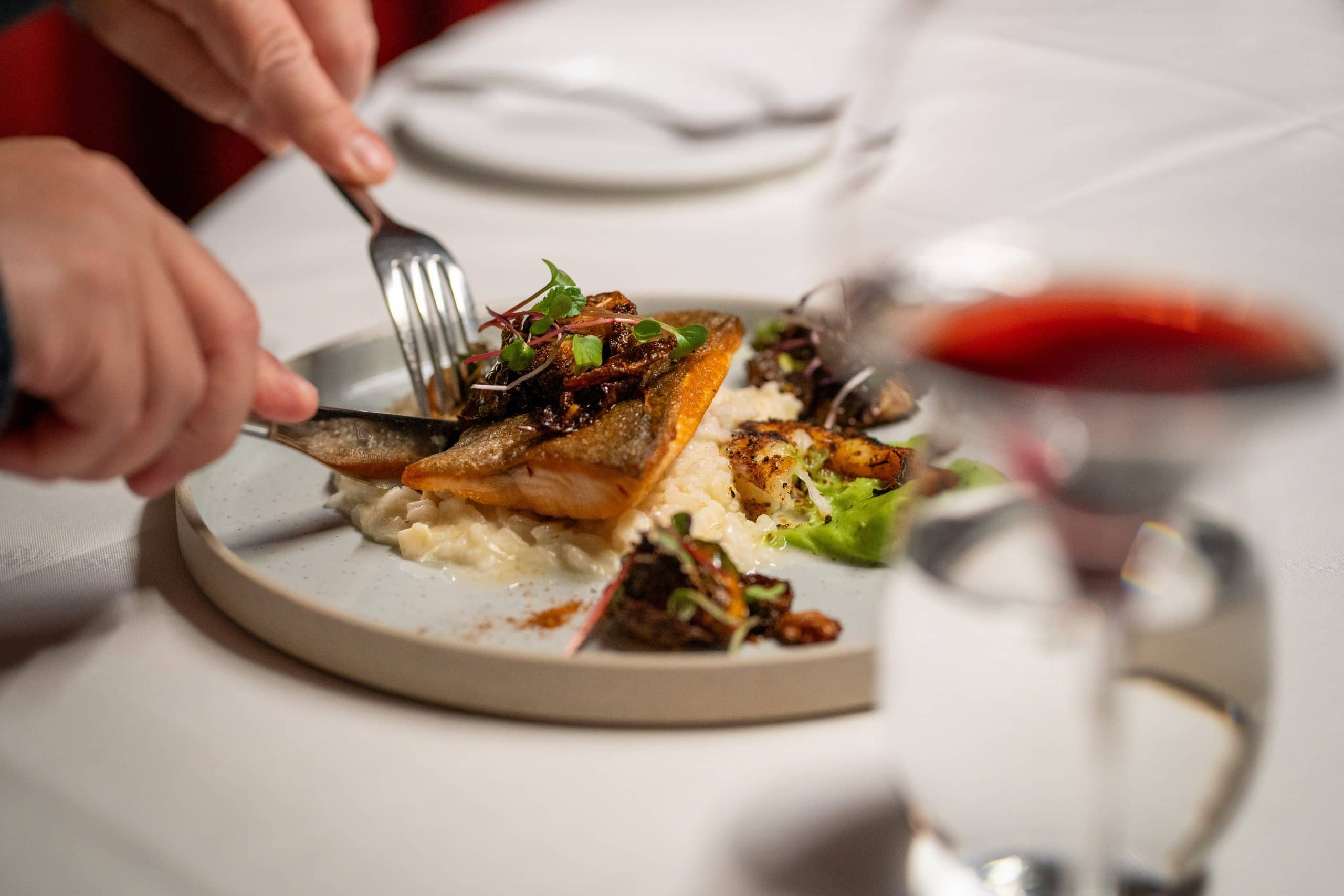Cutting into a delicious meal at AG Inspired Cuisine